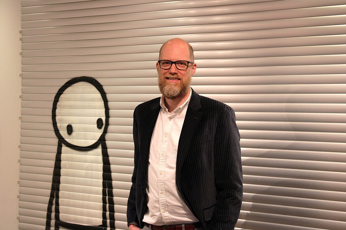 Christiaan stands in front of cartoon-like street art