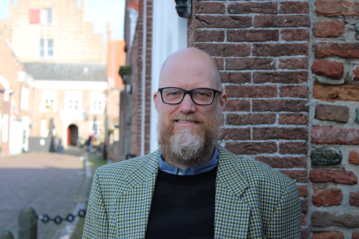 Christiaan before old house and open street